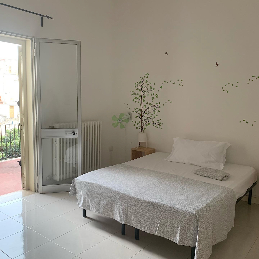 En dubbelsäng i ett mysigt separat dubbelrum på vandrarhemmet Urban Oasis i Lecce Italien
