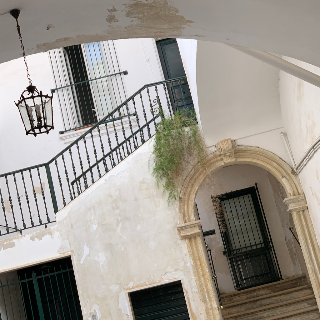 En vackert vitputsad innergård med en vacker trappa i Lecce i Apulien Italien