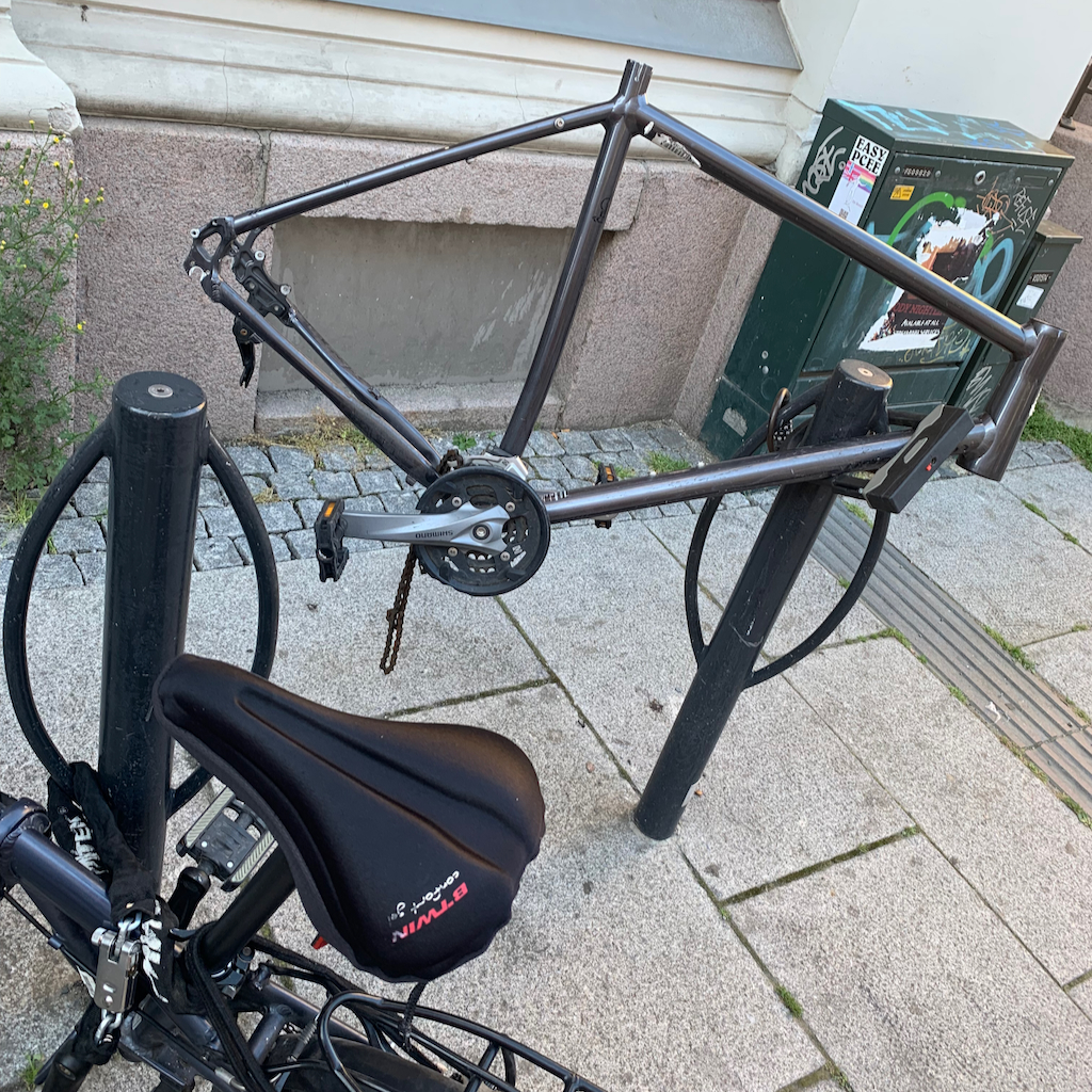 Cykelparkering på gatan bredvid lemlästad cykel