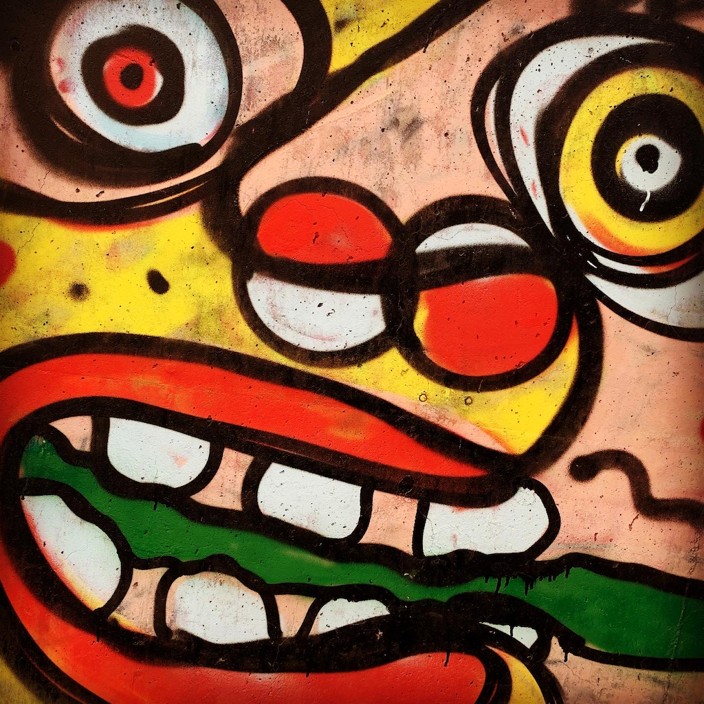 Streetart i Quartier dell Ortica i Milano föreställande ett färgglatt clownansikte