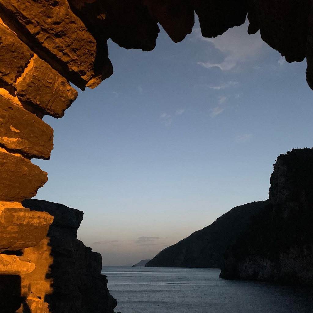 En vacker smymningsbild fotad ut en glugg i en stenmur i Porto Venere i Italien