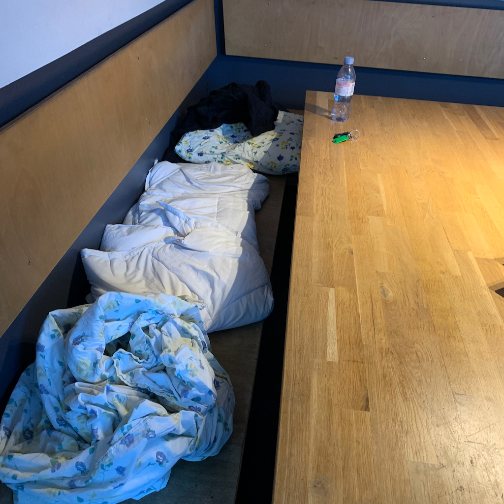 Sängkläder på en kökssoffa på ett vandrarhem i Basel