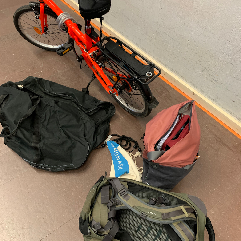 En fällbar cykel, en ryggsäck och cykelväska på en flygplats
