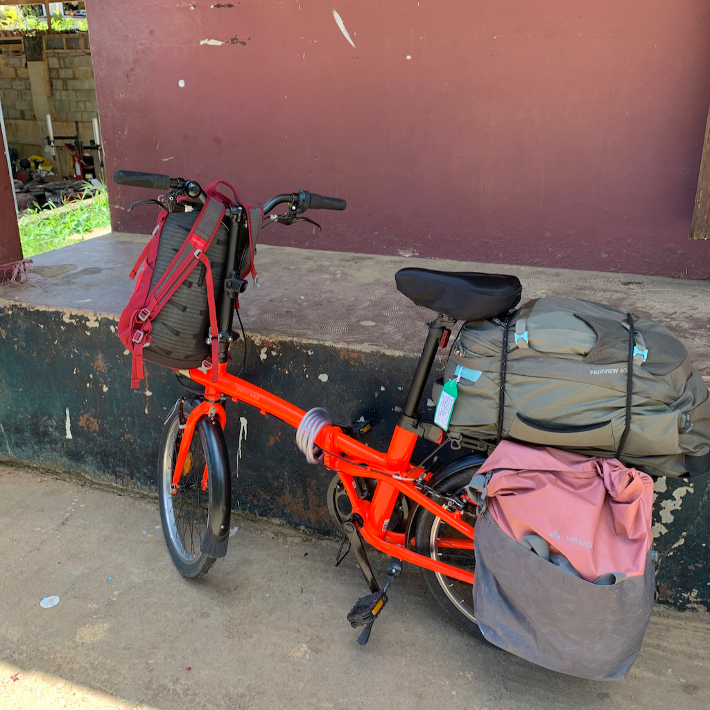 En röd fällbar cykel med packning fastspänd på pakethållaren på Mahé Seychellerna