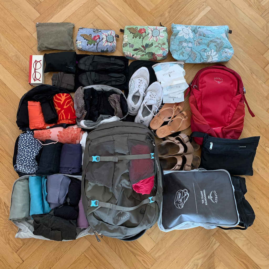 Hela min packning inklusive necessärer och tre väskor uppradad på ett parkettgolv