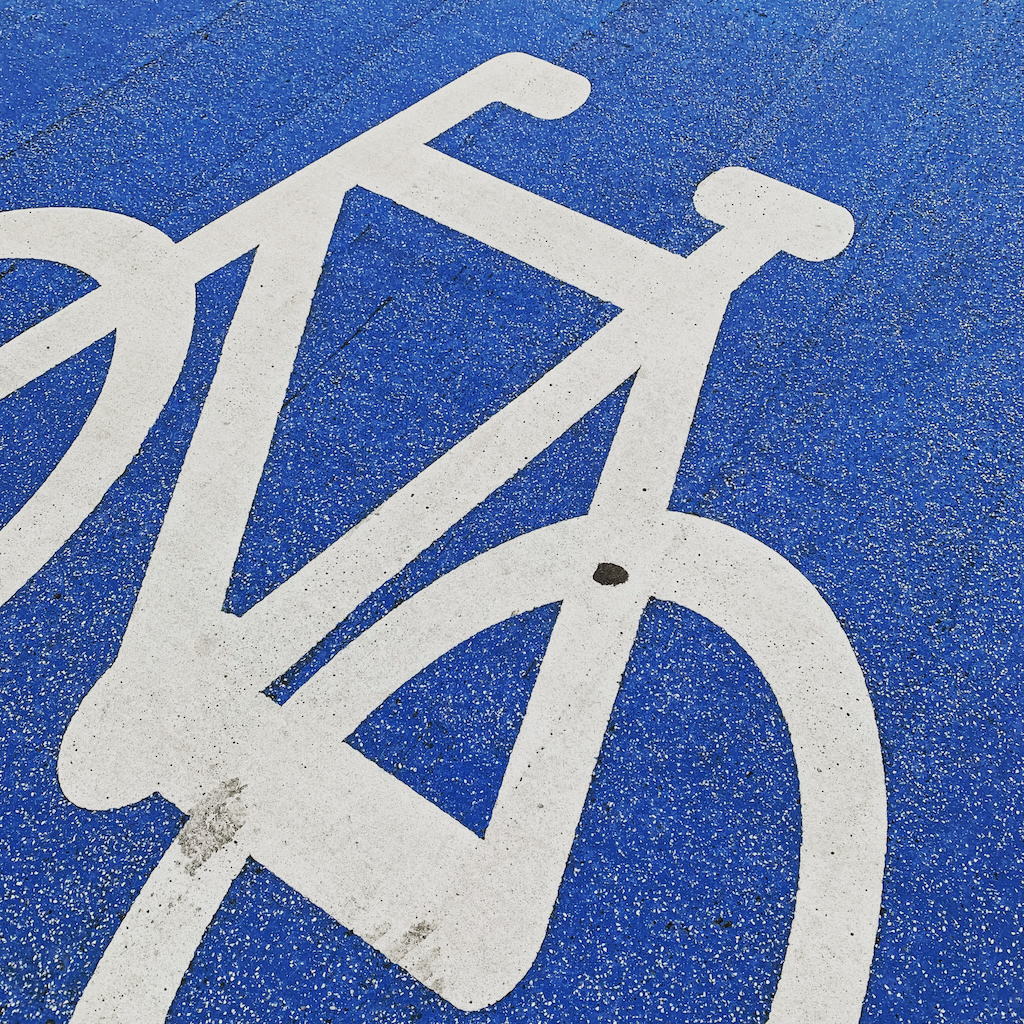 En vit cykel på ett blåmålat cykelfält i Köpenhamn, Danmark