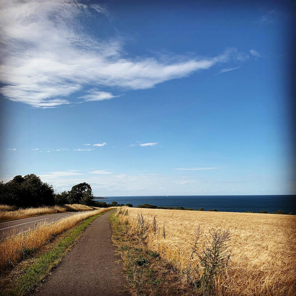 En landsväg mellan havet och fälten mellan Gudhjem och Svaneke på Bornholm i Danmark