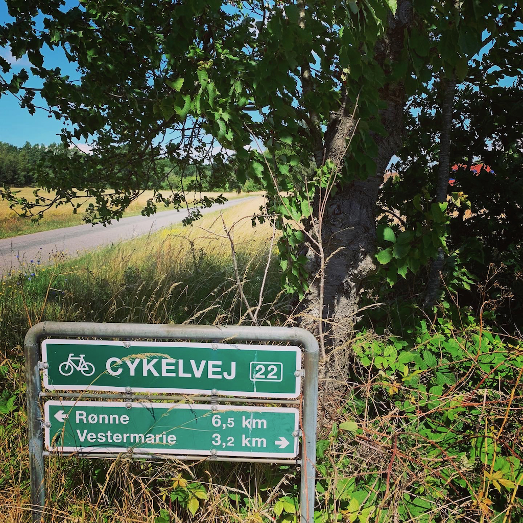 En skylt för en cykelväg som anger avstånd till Rønne och Vestermarie på Bornholm i Danmark