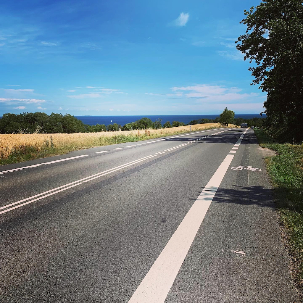 En landsväg mellan havet och fälten mellan Gudhjem och Svaneke på Bornholm i Danmark