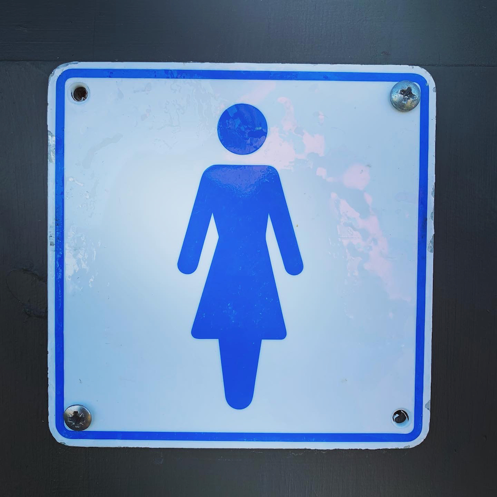 En skylt för damtoalett utmed vägen på Bornholm i Danmark