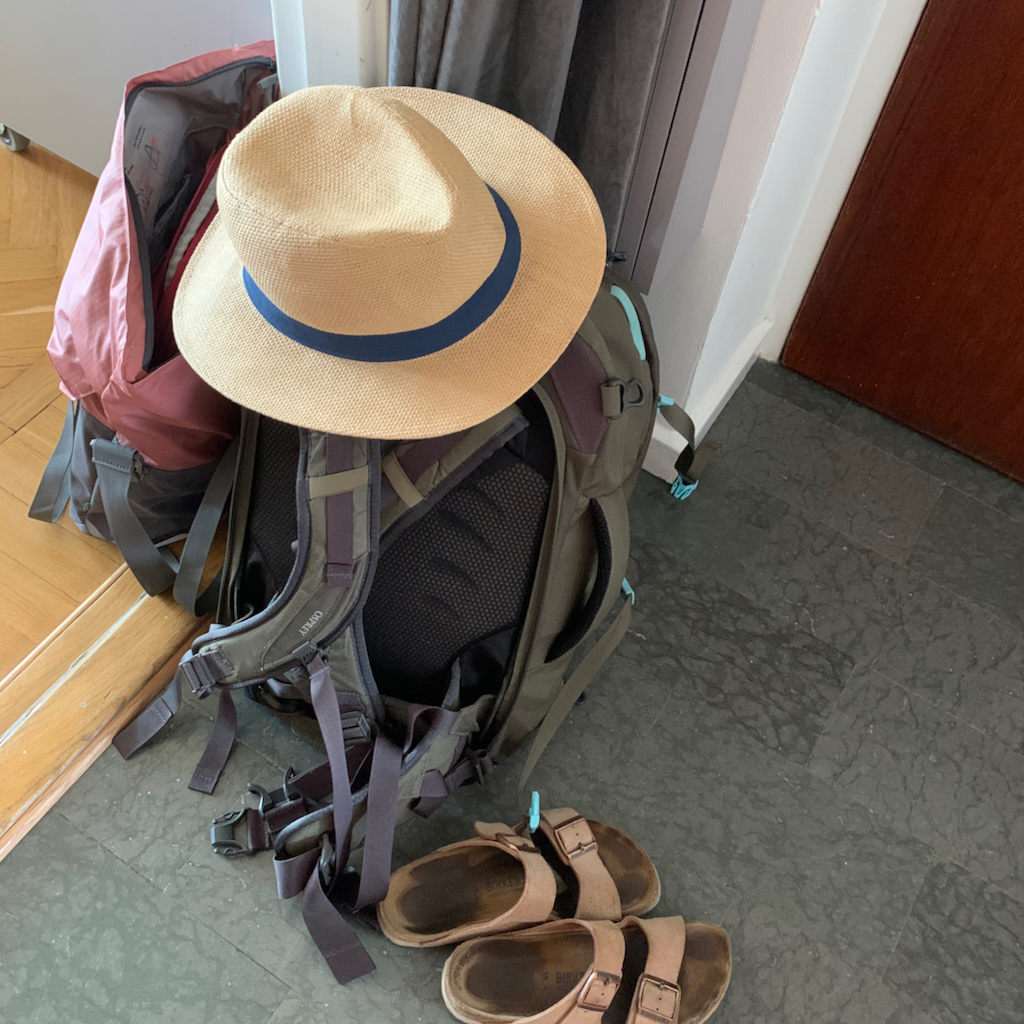 Packning och solhatt på ett hallgolv
