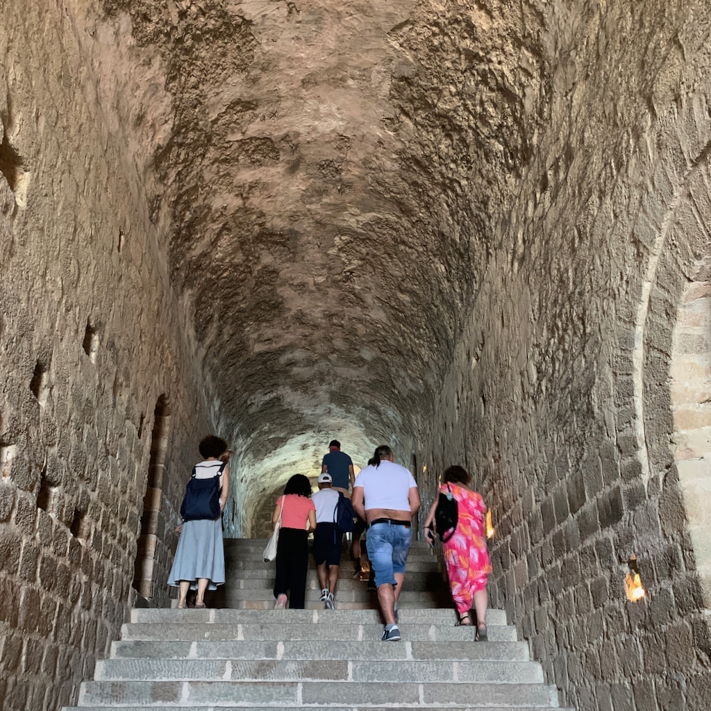 Turister i ett slottsvalv på Mont Saint Michel i Frankrike