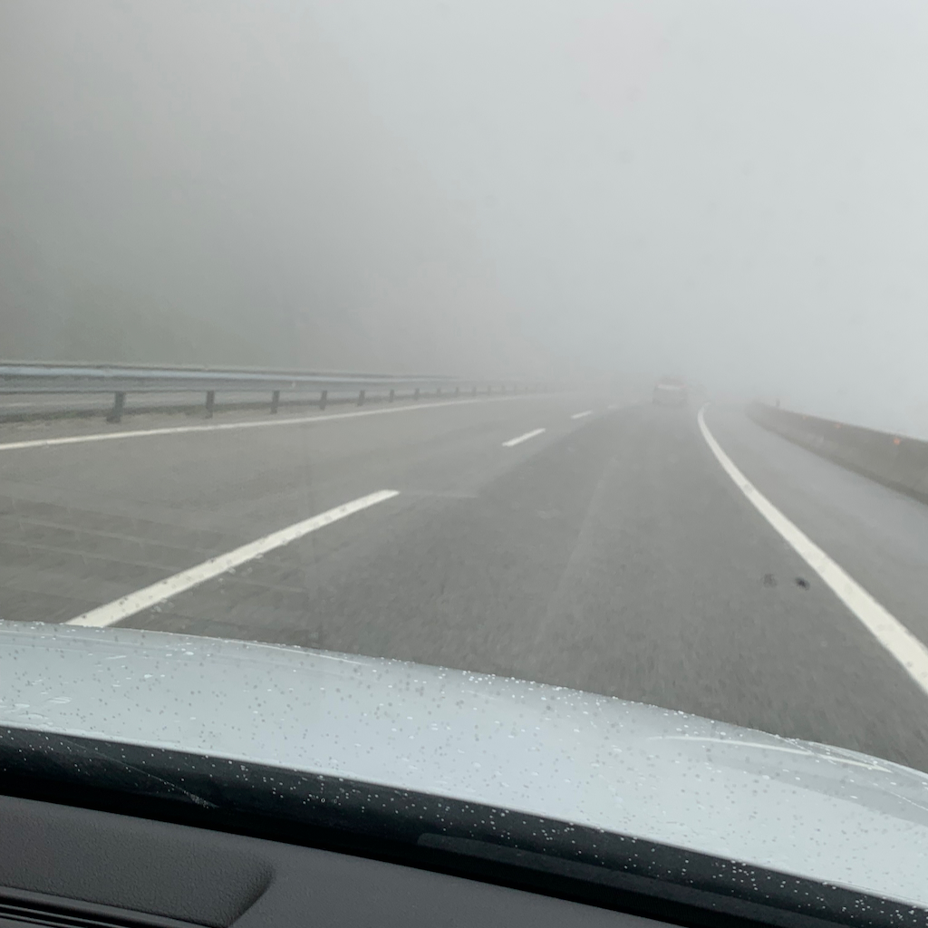 En dimmig och regnig asfalterad väg med skymd sikt i spanska San Sebastian