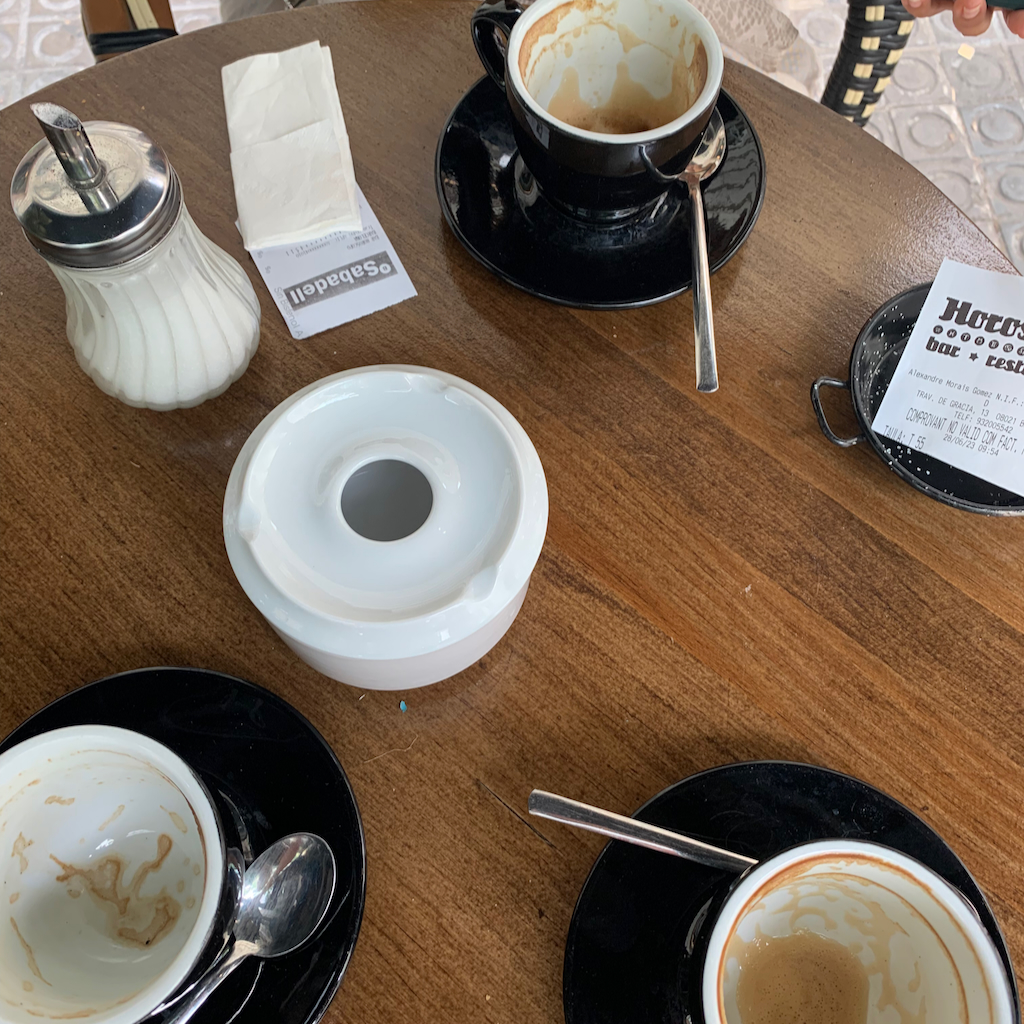 Ett cafébord med askkopp och urdruckna kaffekoppas i spanska Barcelona