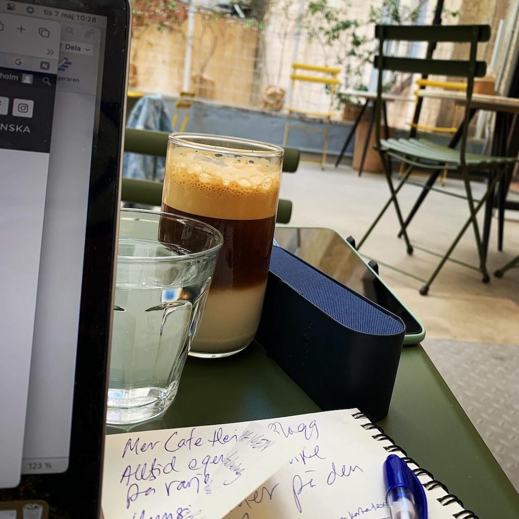 En digital nomad med sin uppslagna dator på ett cafebord i Aten i Grekland.