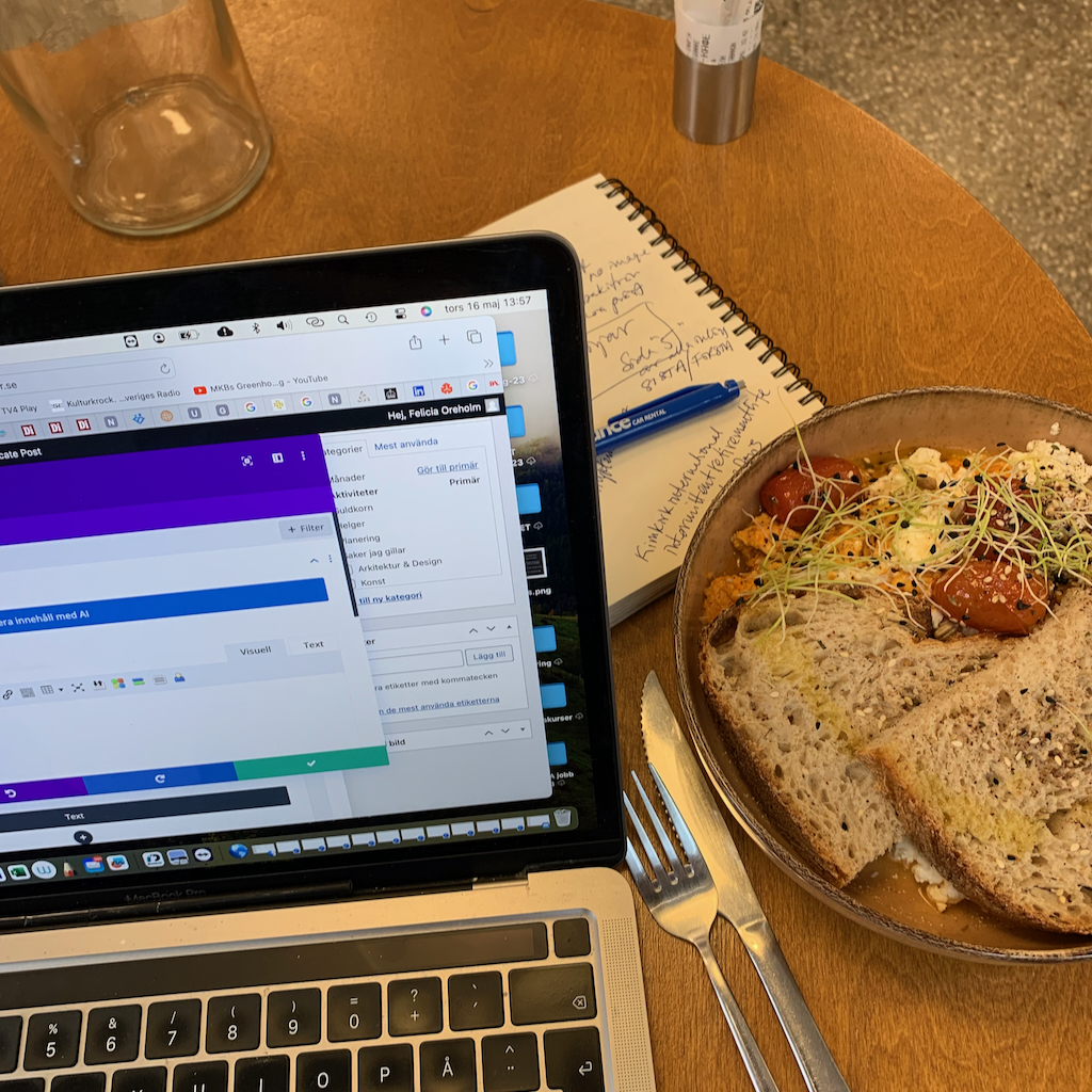 En digital nomad med sin uppslagna dator på ett cafebord i Aten i Grekland.