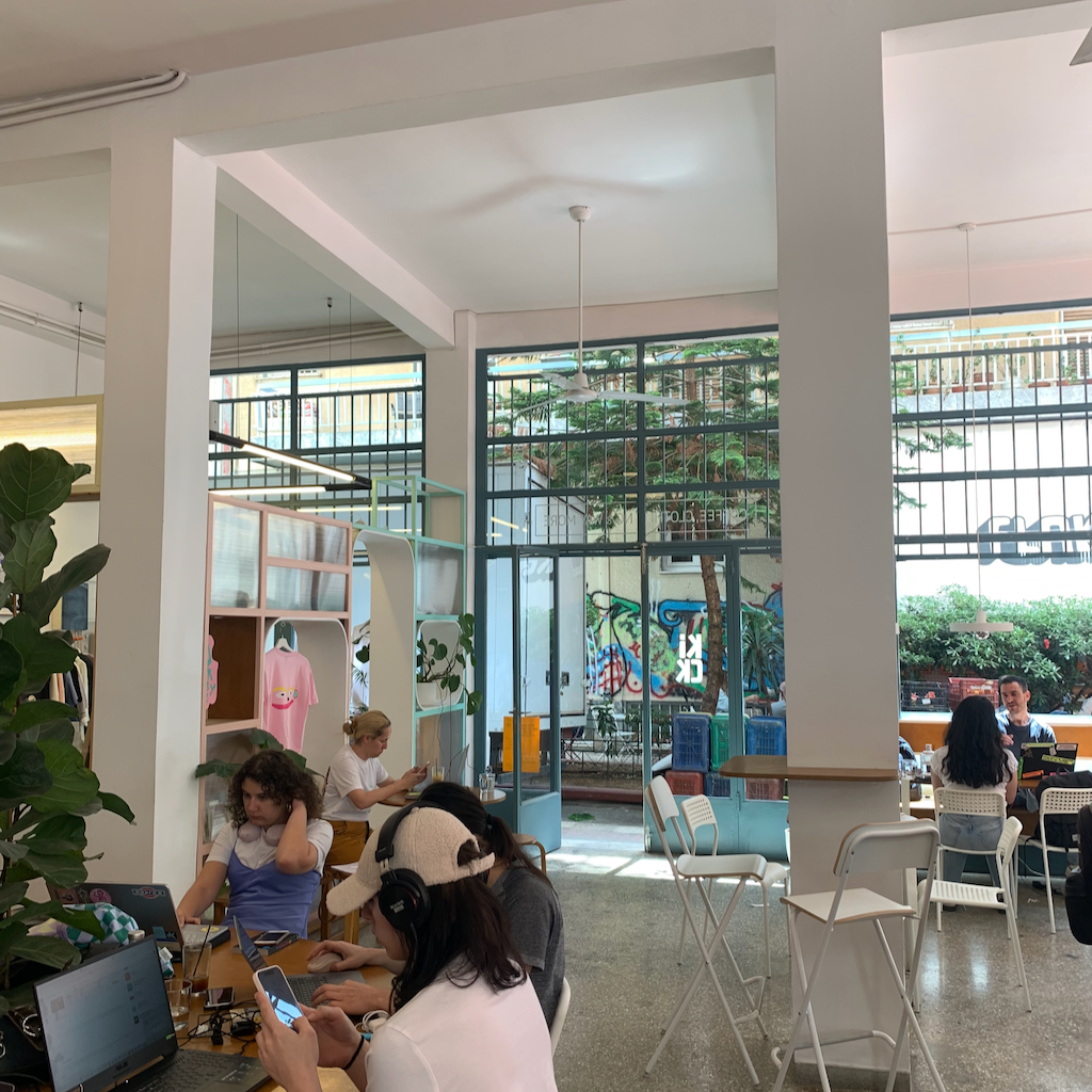 En digital nomad med sin uppslagna dator på ett cafebord i Aten i Grekland.