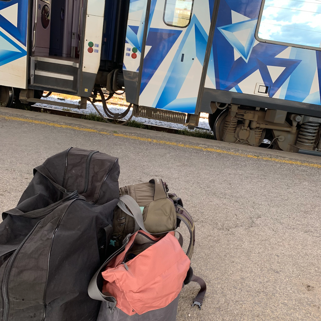 En en grekisk tågvagn med grafiskt blåvitt mönster på en perrong med bagage i förgrunden.
