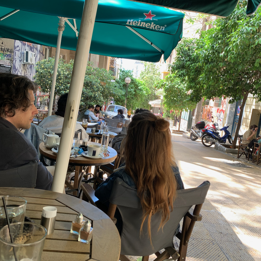 En man och kvinna som sitter på caféet Intriga i stadsdelen Exharchia i Aten.