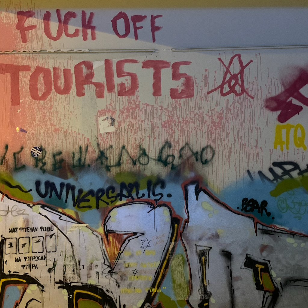 Klotter på en fasad i stadsdelen Exharchia i Aten som säger Fuck off tourists.
