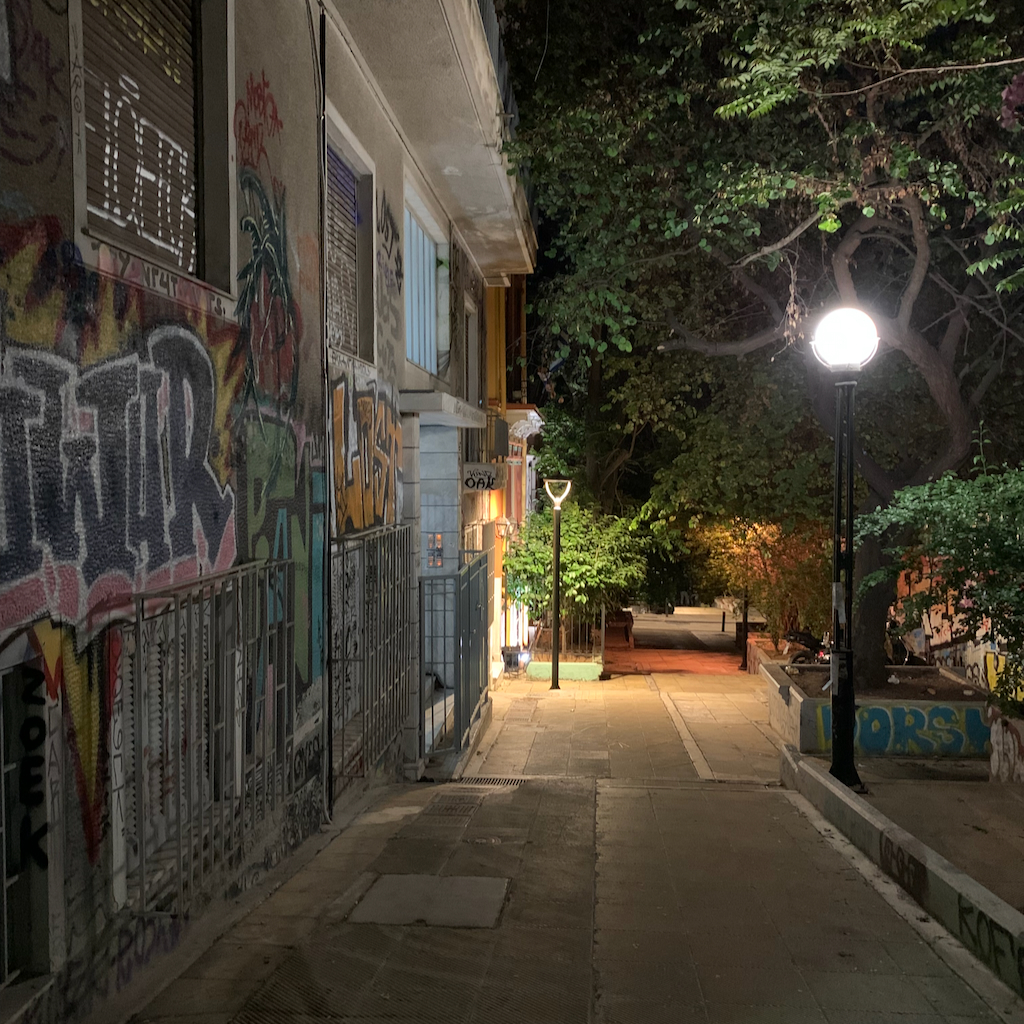 En mörk gata i stadsdelen Exharchia i Aten, upplyst av en gatlampa.