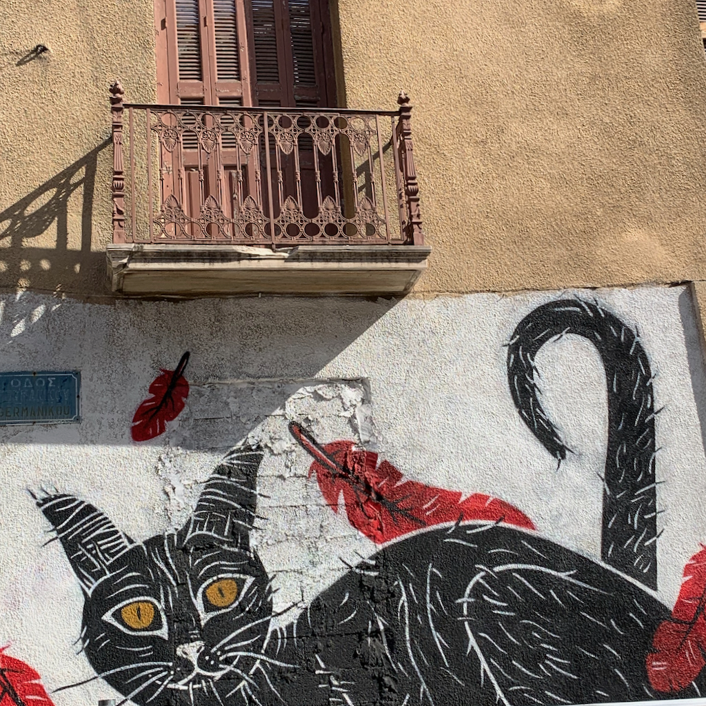 Grafitti föreställande en svart katt på en husfasad i Aten.