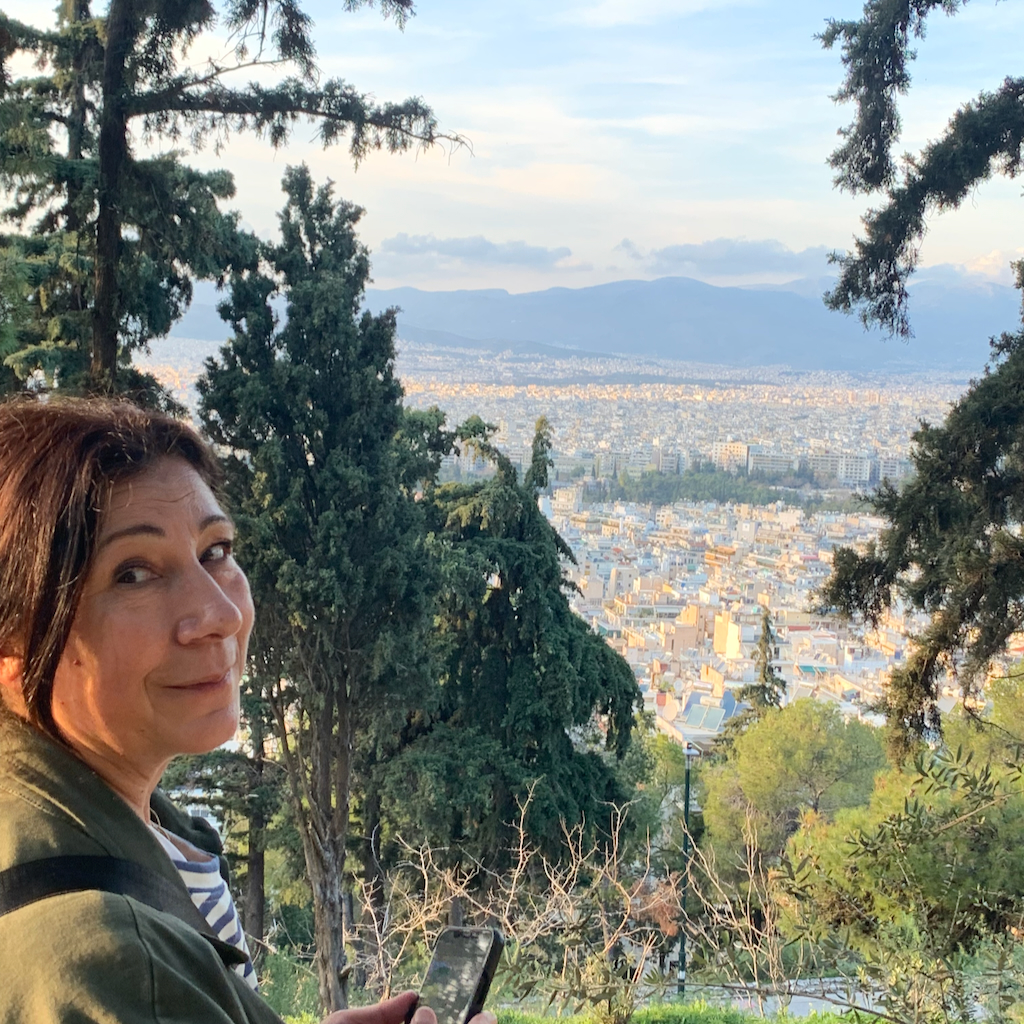En kvinna står och tittar ut över Aten från Mount Lycabettus.